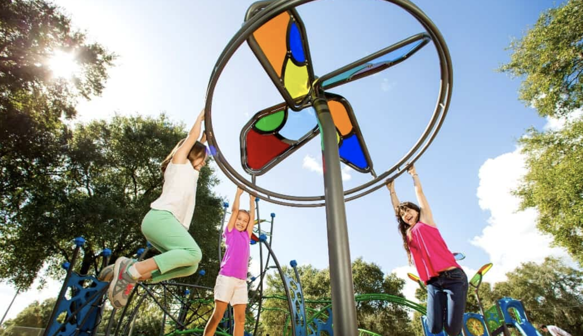 Children playing on a community playground under a bright Texas sky